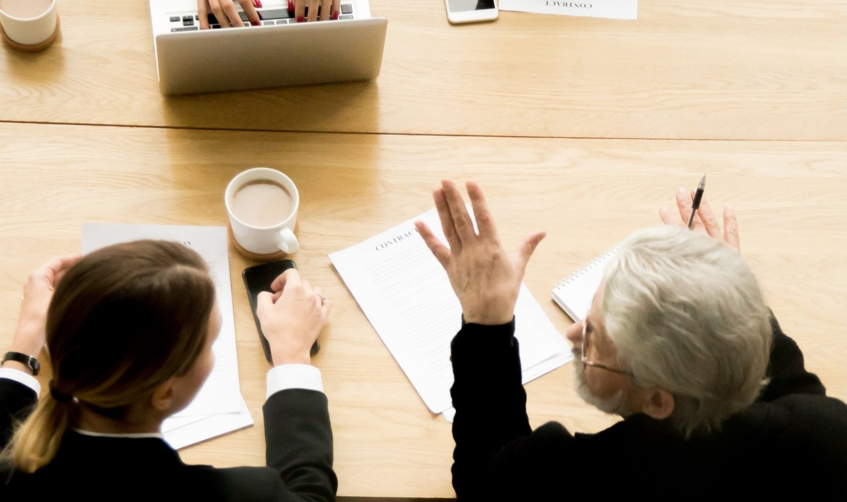 Senior businessman talking at group contract negotiations, vertical top view